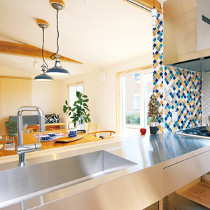 ステンレスの調理台にタイルをあしらったキッチン。住設機器は住む人の好みに対応