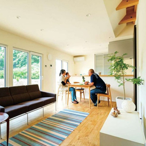  南向きの広いリビングは、栗の無垢床と漆喰壁に囲まれた清々しい空間。<br>
壁側の格子になった吹き抜けが、エアコンの冷気・暖気を運んでくれる